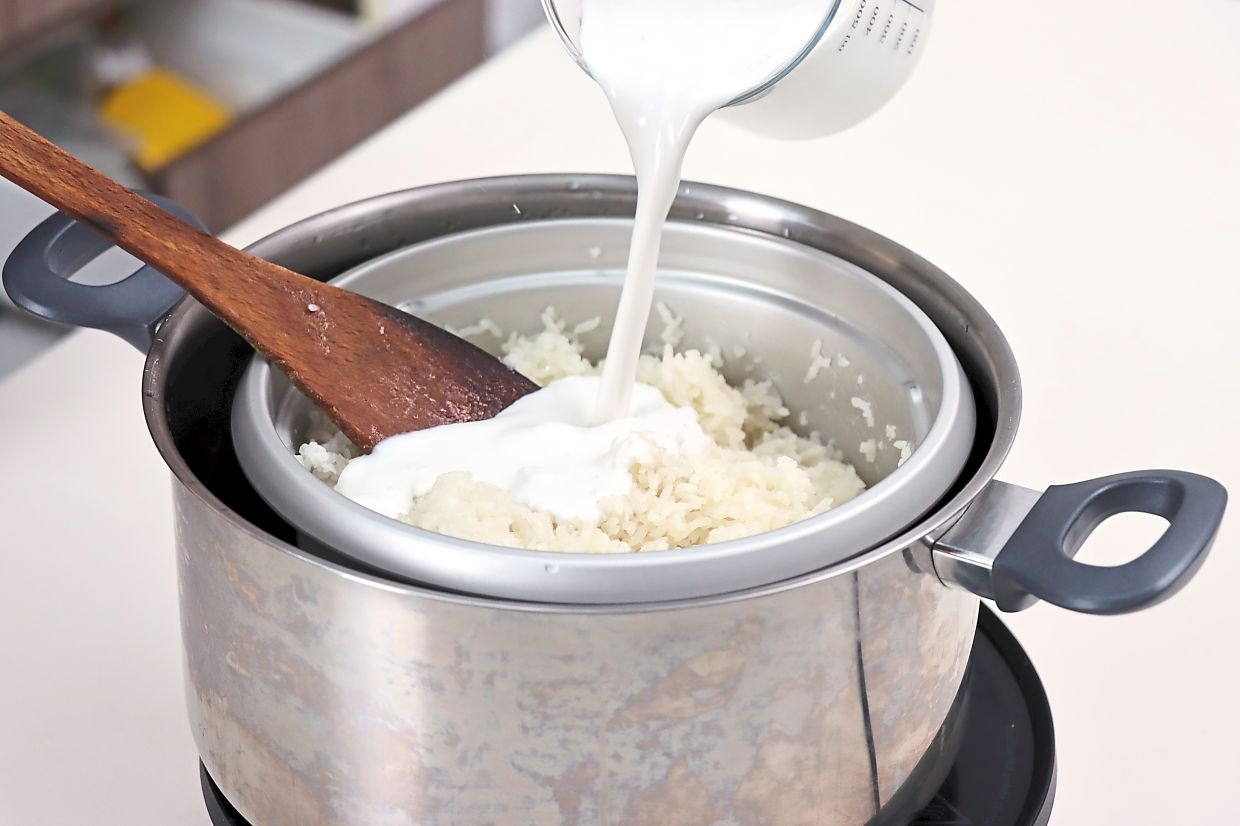 Drain the rice, steam it, then fluff, add coconut milk and salt before steaming again. Spread it out to cool for rolling.