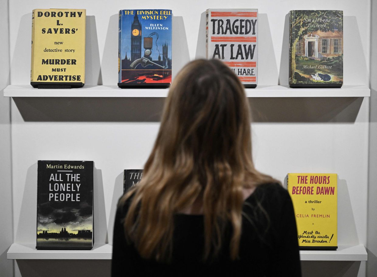 A visitor takes a look at early edition books - from the Cambridge University Library collection - at the exhibition 'Murder By The Book.' Photo: AFP 