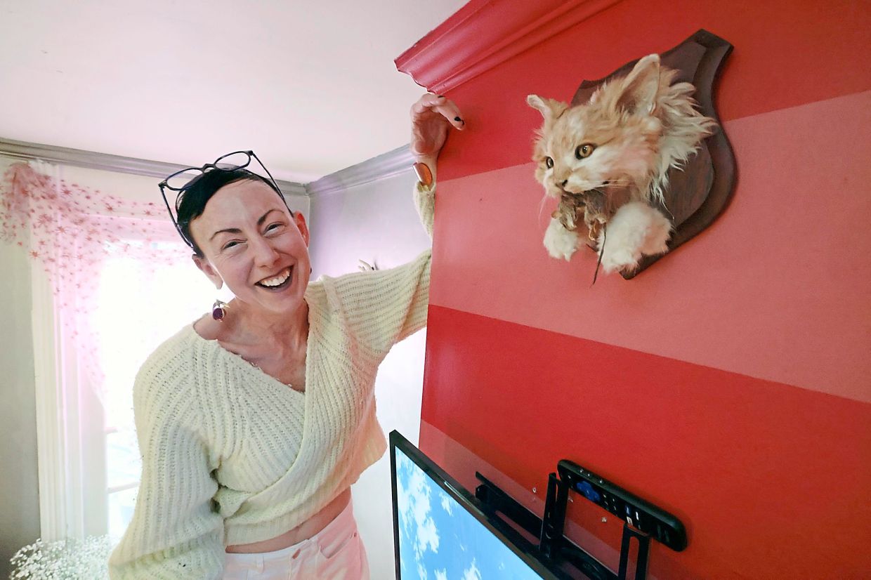 Kate Swan and her preserved cat, Krusty Noodles, in her home in Jenkintown, Pennsylvania, the United States. Krusty Noodles was a beloved but fierce hunter cat, now mounted in the dining room.