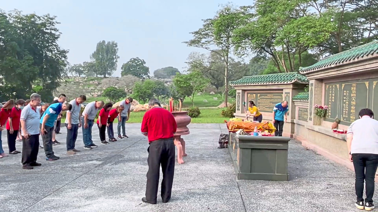 Members of Selangor and Kuala Lumpur Char Yong Association performing the Three Bows ritual to their ancestors at a cemetery.
