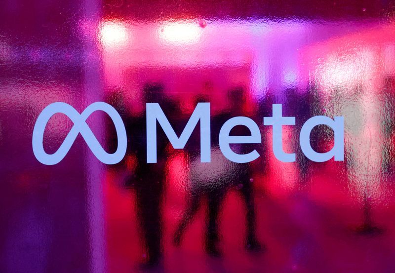 FILE PHOTO People walk behind a Meta Platforms logo during a conference in Mumbai India September 20 2023. REUTERSFrancis MascarenhasFile Photo