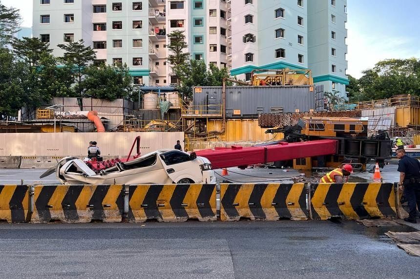 The van appears to have been crushed by the impact of the fallen crane boom arm. - ST PHOTO: ANDREW WONG