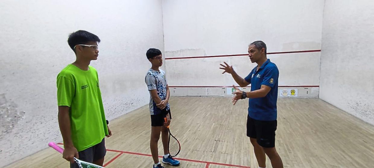 You’re the future: Aaron, who is the Squash Academy of Penang head coach, instructing M. Nikhileswar (centre) and Ivan Chang Kia You (left) during a training session at the Nicol David International Squash Centre.