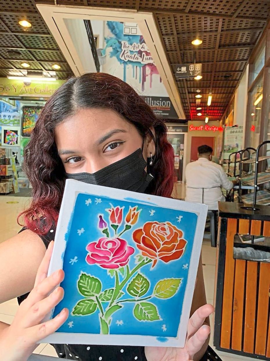 Ishani with a completed batik piece at a workshop; 
