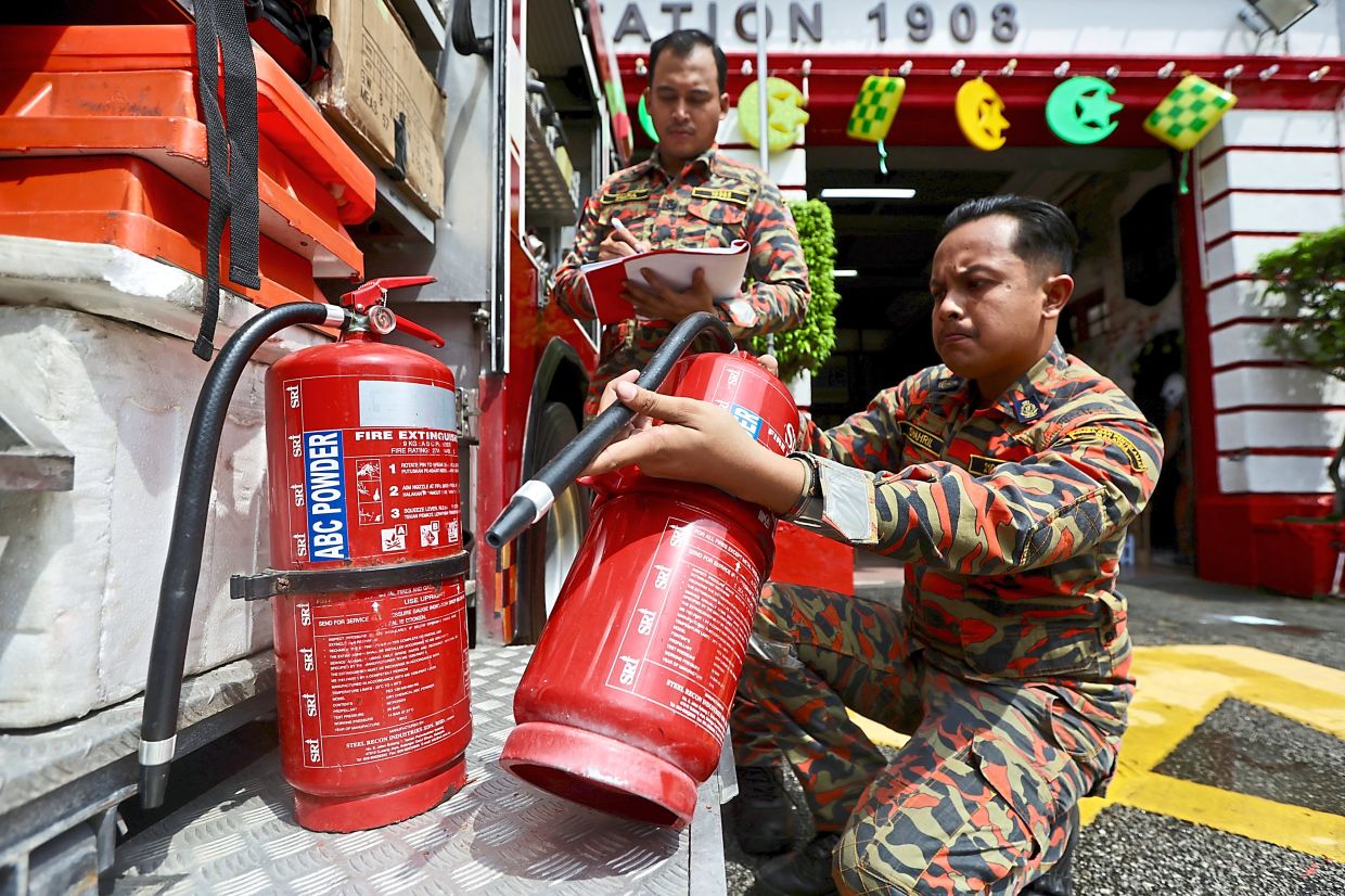 Beach Street Fire Station officers preparing fire extinguishers for the community-based fire responders training programme.