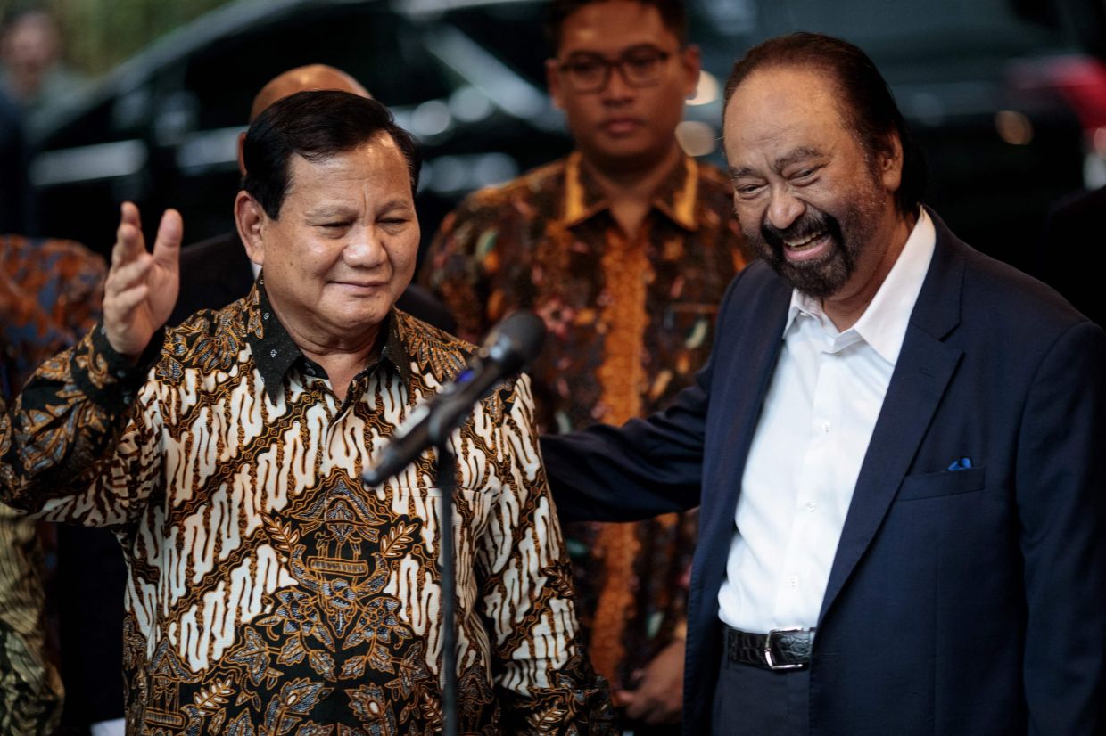 Indonesia's President-elect Prabowo Subianto (left) and Surya Paloh, chairman of the Nasdem Party and owner of Metro TV, pose for the media after their meeting at Prabowo's home in Jakarta on Thursday, April 25, 2024.- AFP