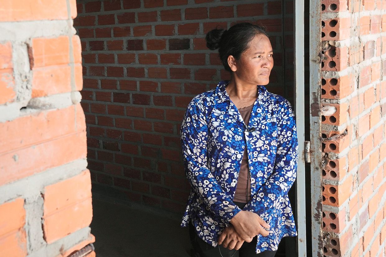 Chhem Hay, 37, stands at a main door of her house under construction at Run Ta Ek village in Siem Reap province, Cambodia. She decided last June to take the opportunity to move from the village where she’d lived since she was a young teenager to the new settlement. Cambodia’s programme to relocate people living on the famous Angkor archaeological site is drawing international concern over possible human rights abuses. — AP