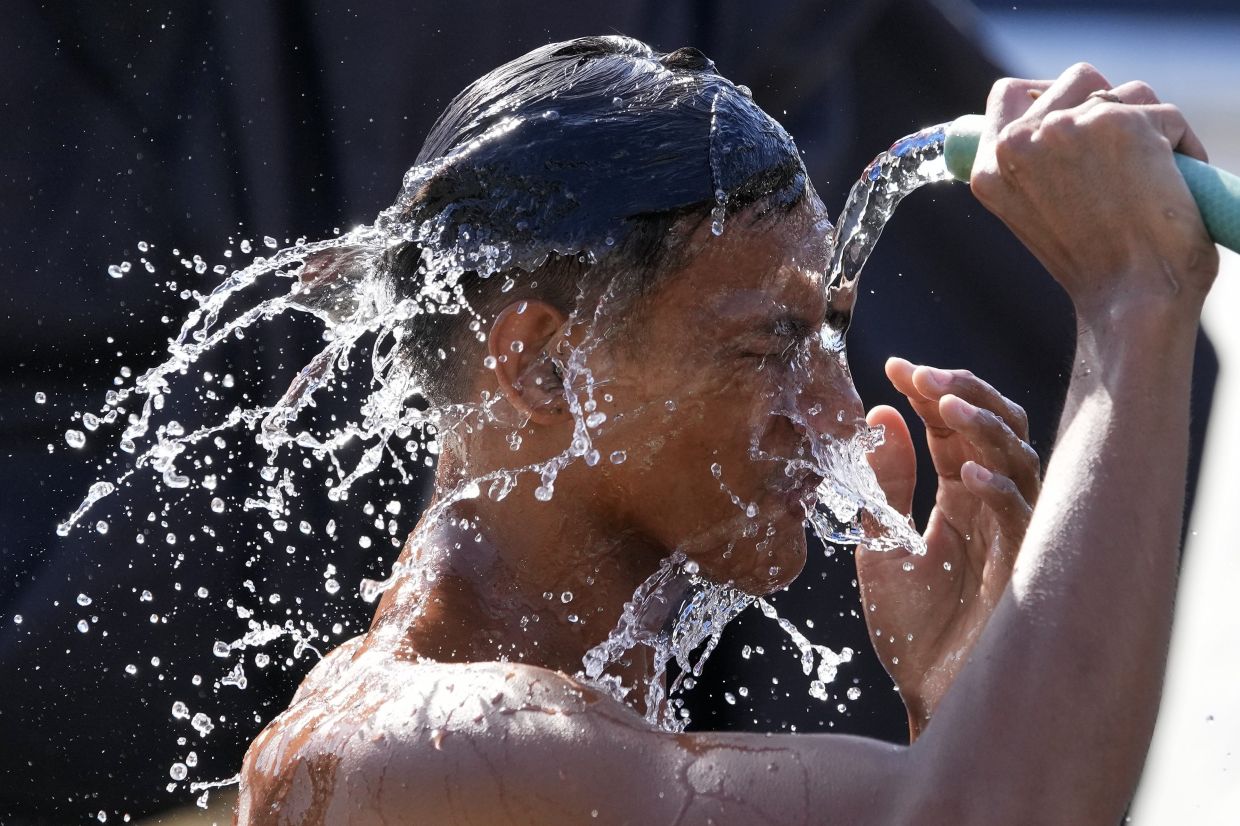 A man douses himself with water along a street as hot temperatures continue in Manila, Philippines on Friday, April 26, 2024. Parts of the country continue to experience extremely hot weather due to the El Nino phenomenon with the highest heat index reaching 48 celsius degrees (118 Fahrenheit) in a northern province. - AP Photo