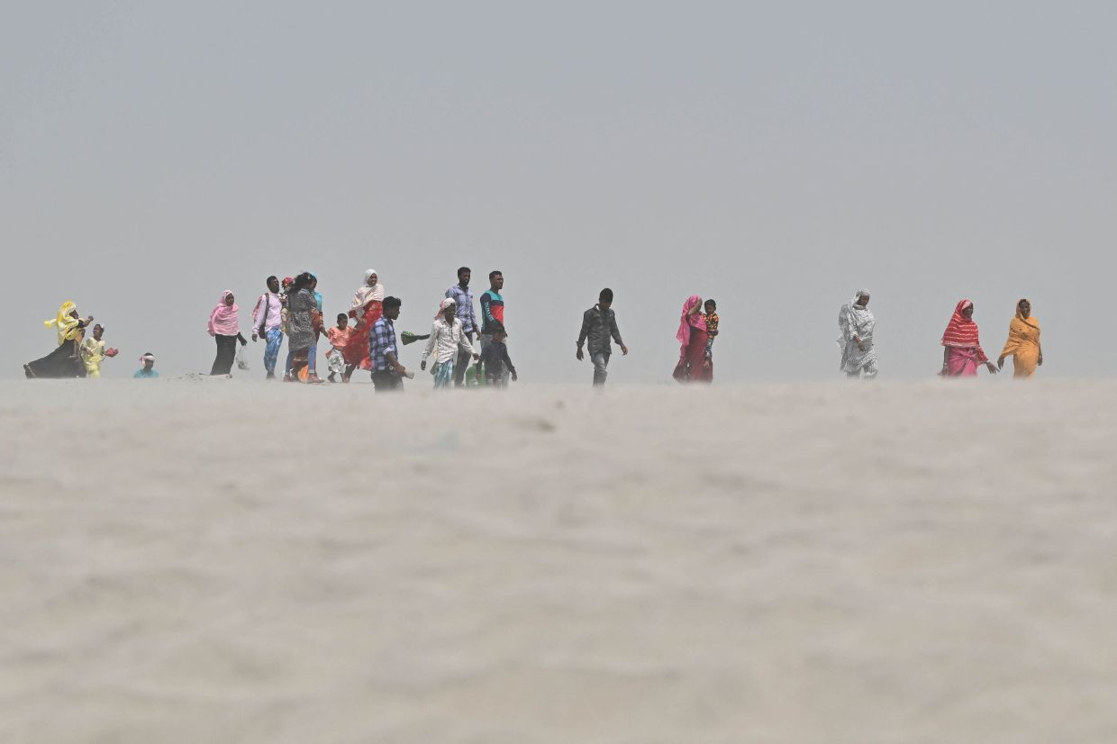 People travel towards a polling station to cast their ballot during the second phase of voting of India's general election at Gashbari village in Darrang district of Assam state on Friday, April 26, 2024. - AFP