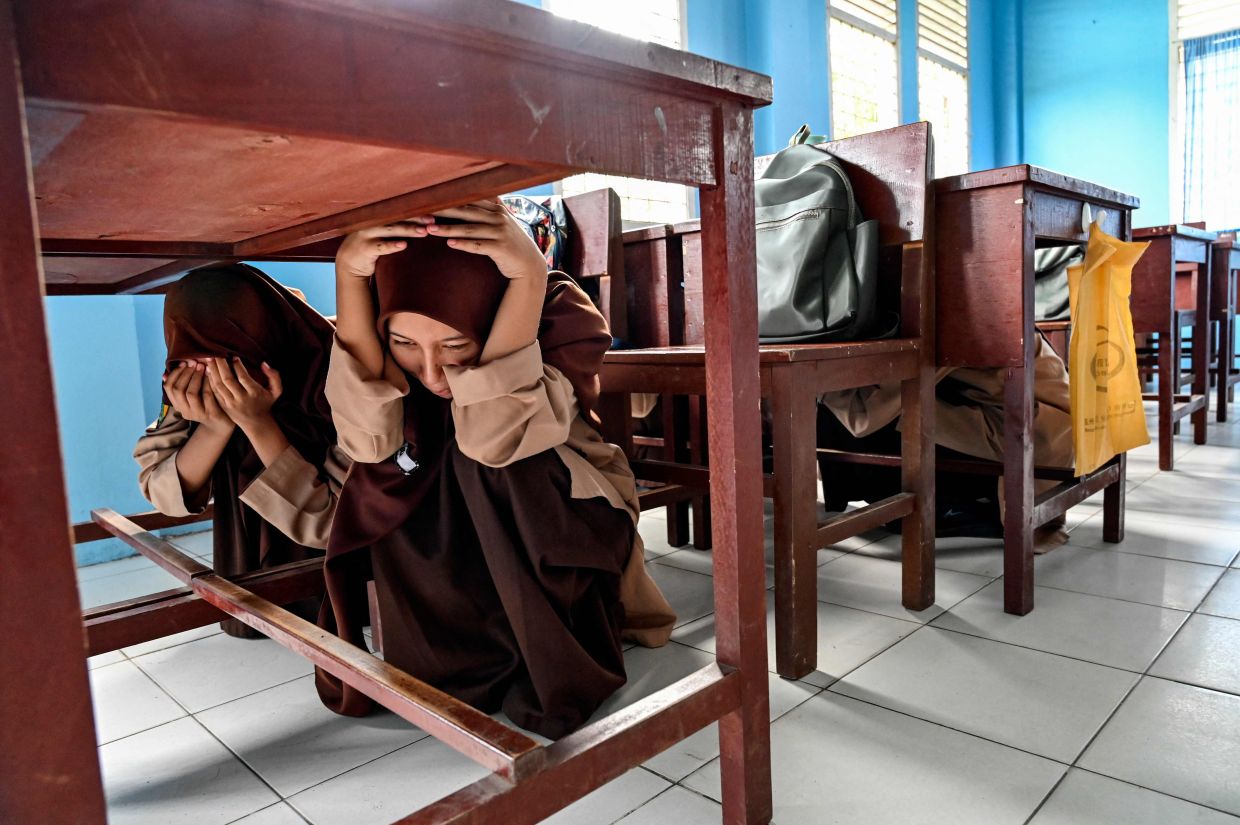 Junior high school students take part in an earthquake and tsunami drill as part of a disaster education programme in Lhoknga, Aceh province on Friday, April 26, 2024. - AFP