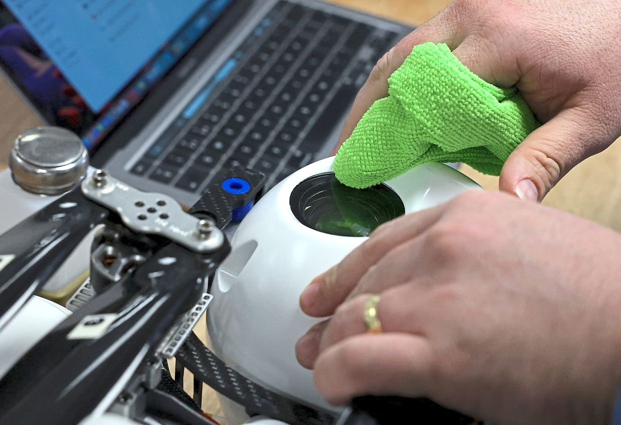 A staff member prepares and cleans a gimbal unit for an Evolve Dynamics Sky Mantis surveillance drone at the laboratories near Guildford, Britain.  — Reuters