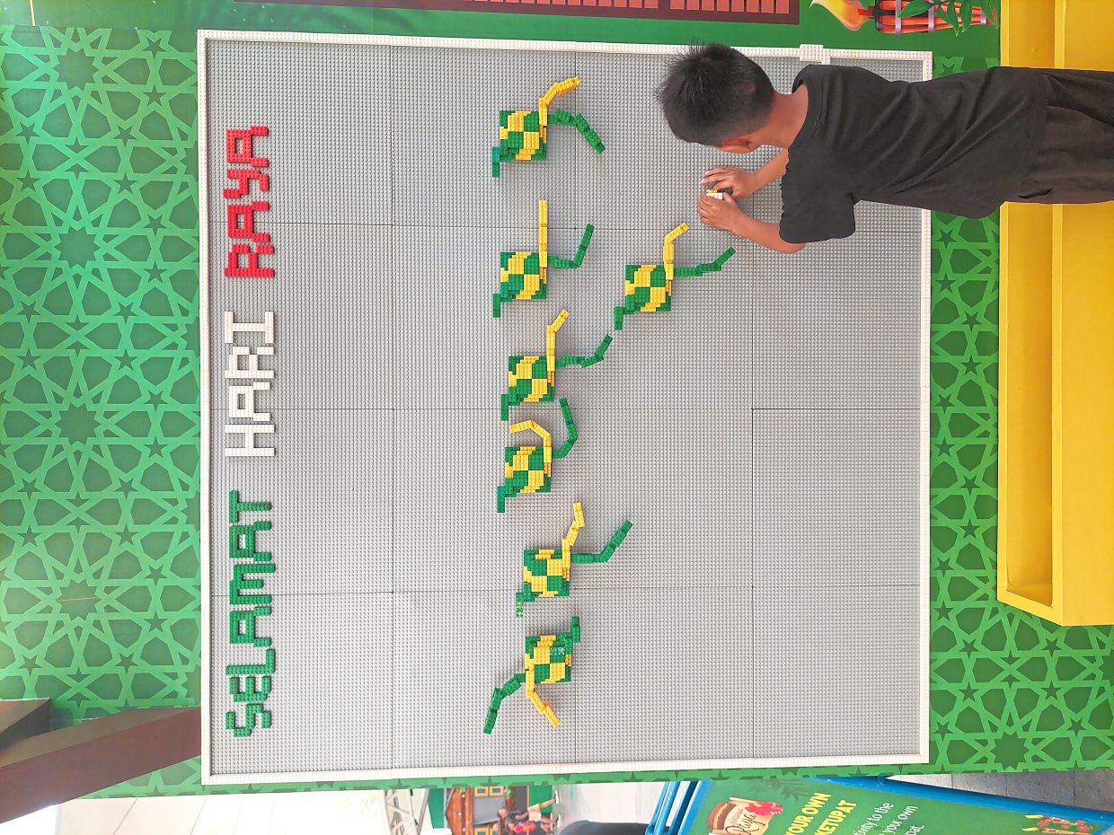 A young boy taking part in a Lego ketupat-making activity, which is part of the 'Nostalgia Raya' festive season programme at Legoland.