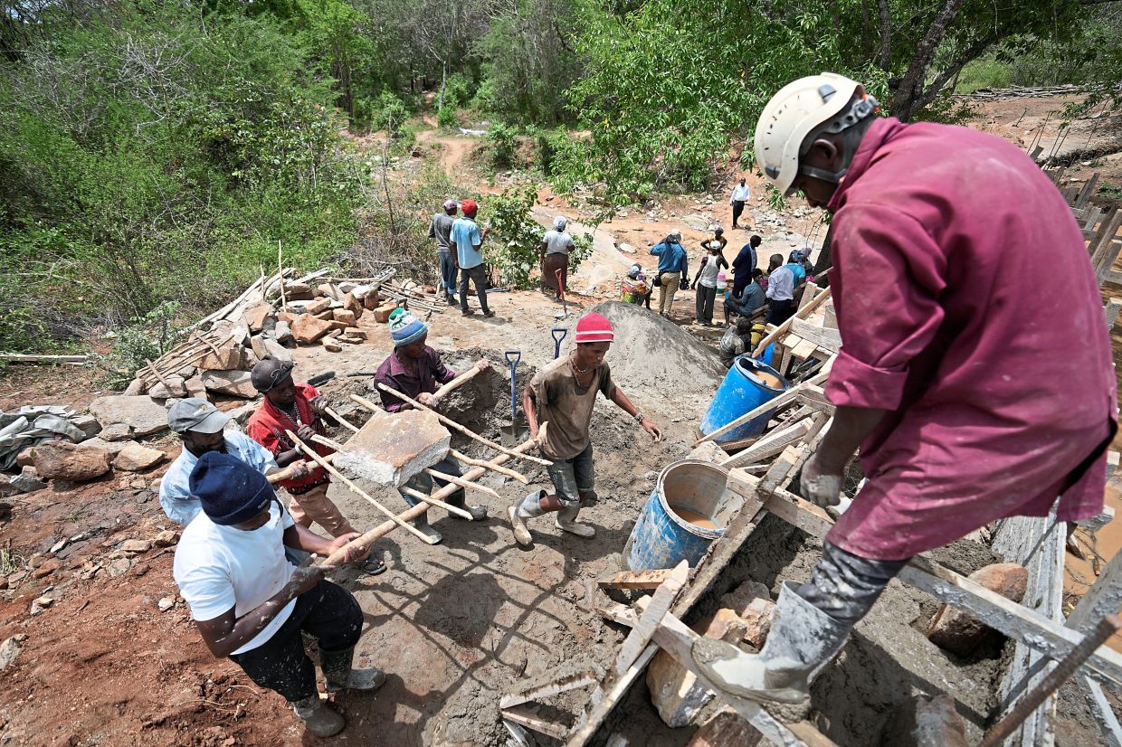 Members of Kyemoo Power constructing a sand dam in Makueni County, Kenya. — AP