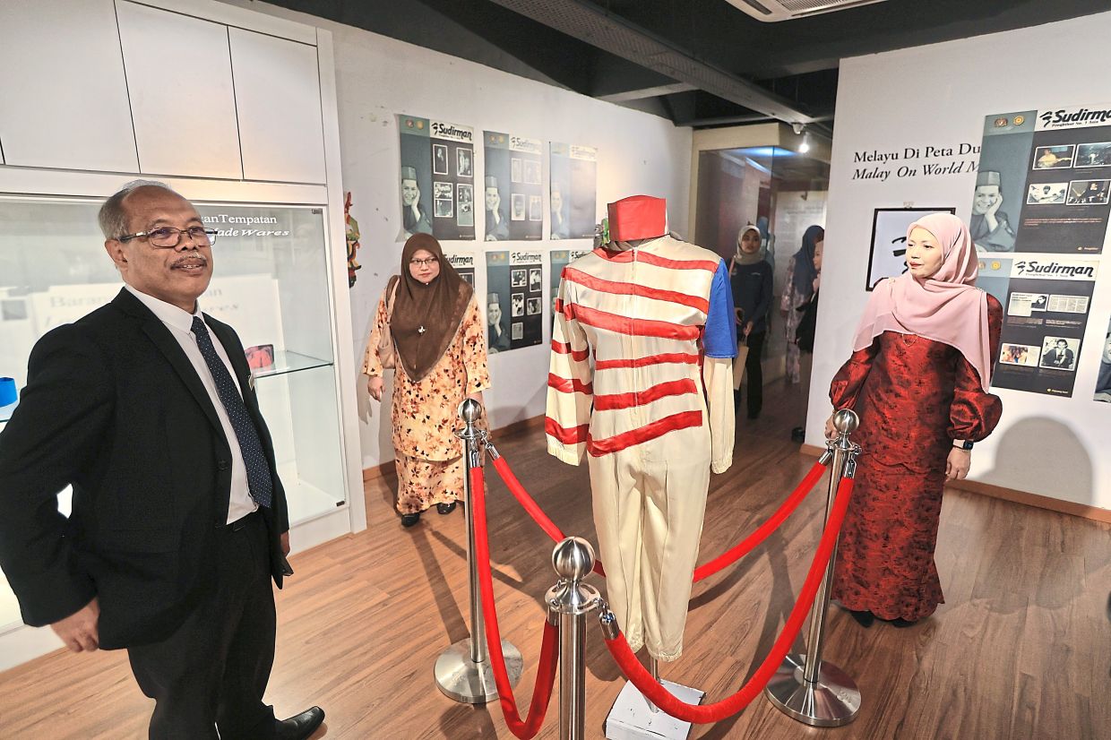 Jaafar Sidek (left) standing beside Sudirman’s iconic costume that is emblematic of the national flag.