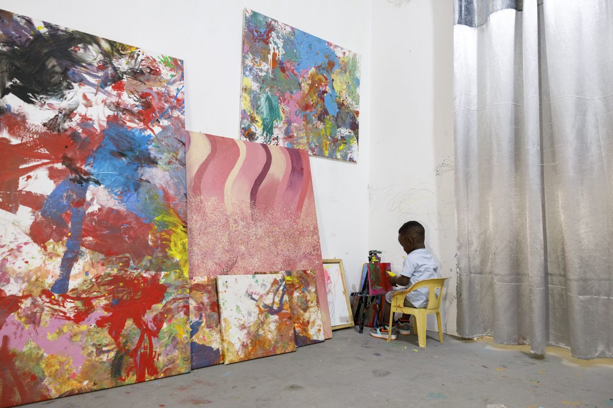 Ace-Liam Ankrah at work, painting a new piece. Photo: AP