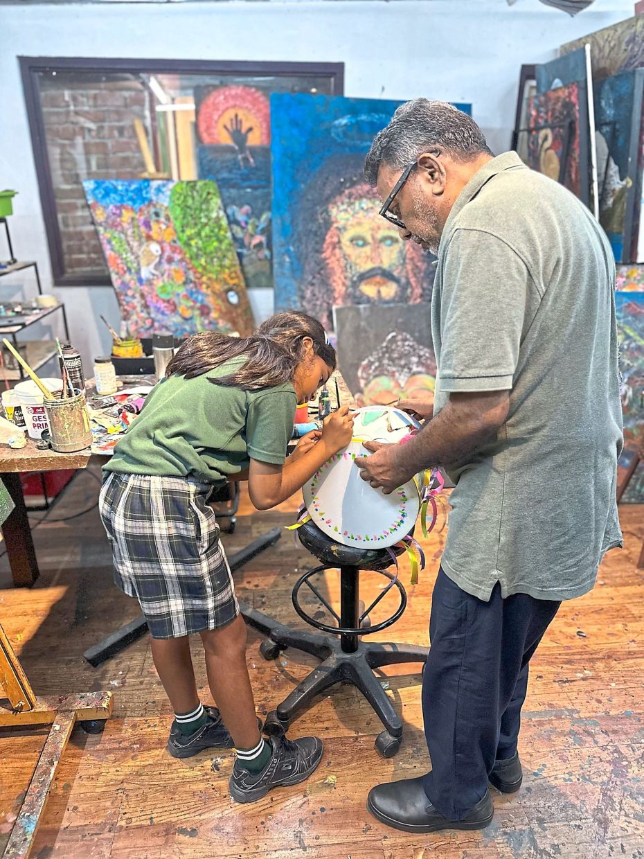 Although he has mostly retired from the business, Panirselvam still maintains a small studio at the back of Passage Thru India, where he still puts together art pieces to adorn the restaurant. He is pictured here with his granddaughter Aarti Laxmi. — GAYA SELVA