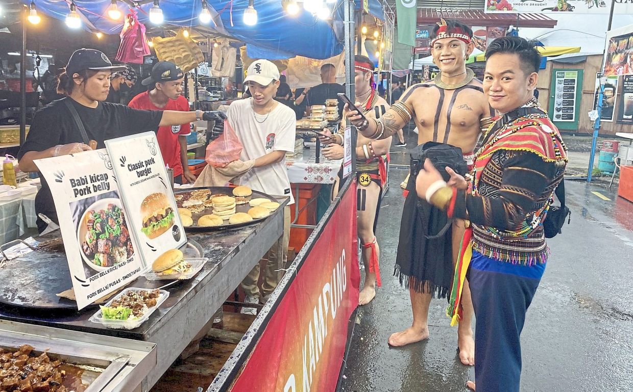 Locals dressed in traditional costumes buying food at one of the many stalls that pop up during the Kaamatan festival in Sabah.— Filepic/The Star