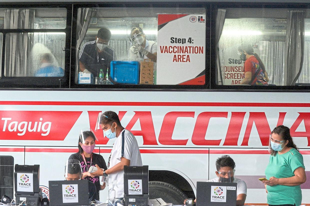 Battle raging in the shadows: Health workers and the government struggled to get Filipinos vaccinated against Covid-19, despite mobile sites like this one, operating in Taguig, Metro Manila, Philippines. At that time, the Philippines had one of the worst inoculation rates in South-East Asia. (Left) The Pentagon is seen in this aerial view in Washington. — Reuters