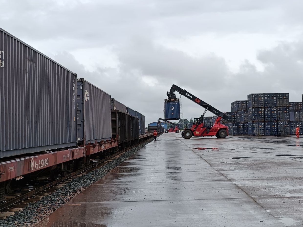 The 1,000km-long Laos-China railway has introduced an attractive option to move transboundary freight from Malaysia across Thailand and Laos to China, and to the rest of the world. Seen here is a cargo handling yard at Vientiane South freight station, where a rotator truck can be seen loading a 20ft container onto the freight wagon. — MENG YEW CHOONG/The Star