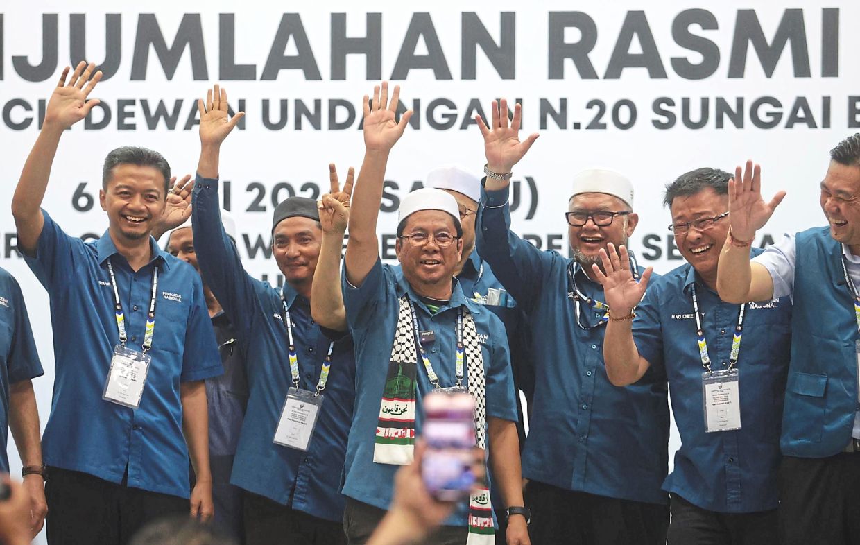 Carrying the torch: Abidin (centre) celebrating his victory with other Perikatan members at the Jawi multipurpose hall in Nibong Tebal. — ZHAFARAN NASIB/The Star
