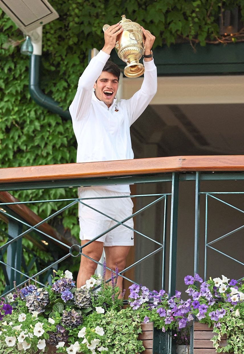 Spain’s Carlos Alcaraz poses with the trophy as he celebrates winning the men’s singles final against Djokovic. — Reuters