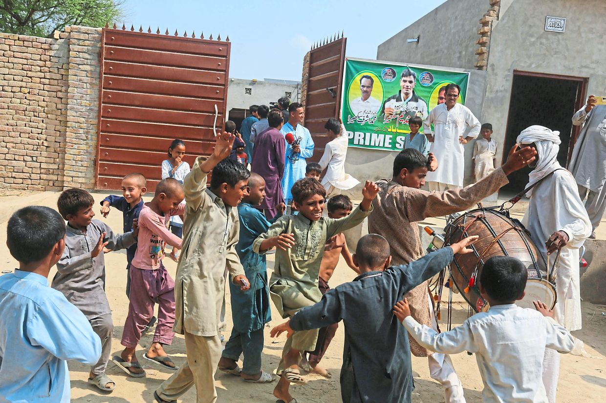 It takes a village: Mian Channu villagers gather to celebrate in front of Arshad Nadeem’s house. — AFP