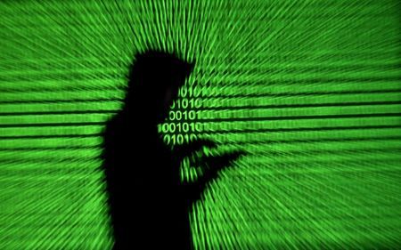 Silhouette of mobile device user is seen next to a screen projection of binary code are seen in this picture illustration taken March 28 2018.  REUTERSDado RuvicIllustrationFile Photo