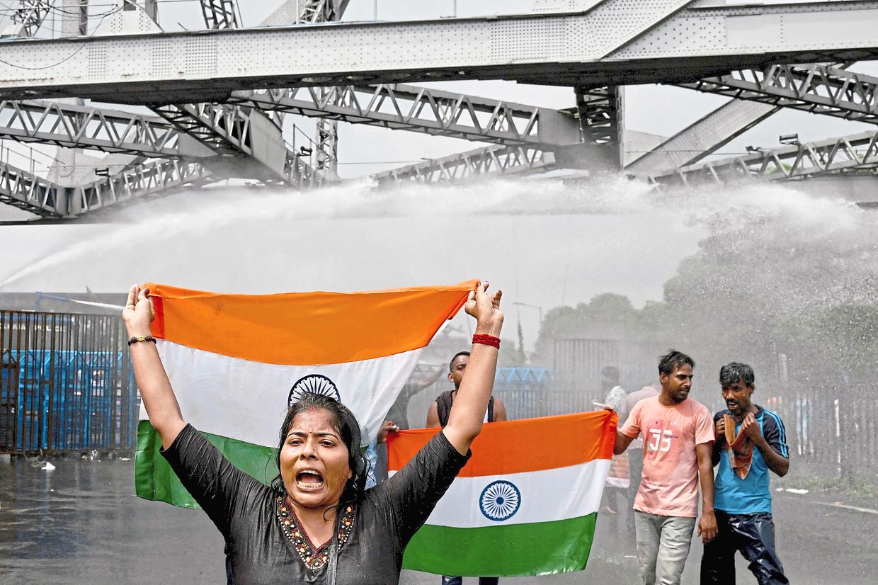 Demanding justice: Protesters marching against police water cannons, near Howrah bridge in Kolkata. — AFP