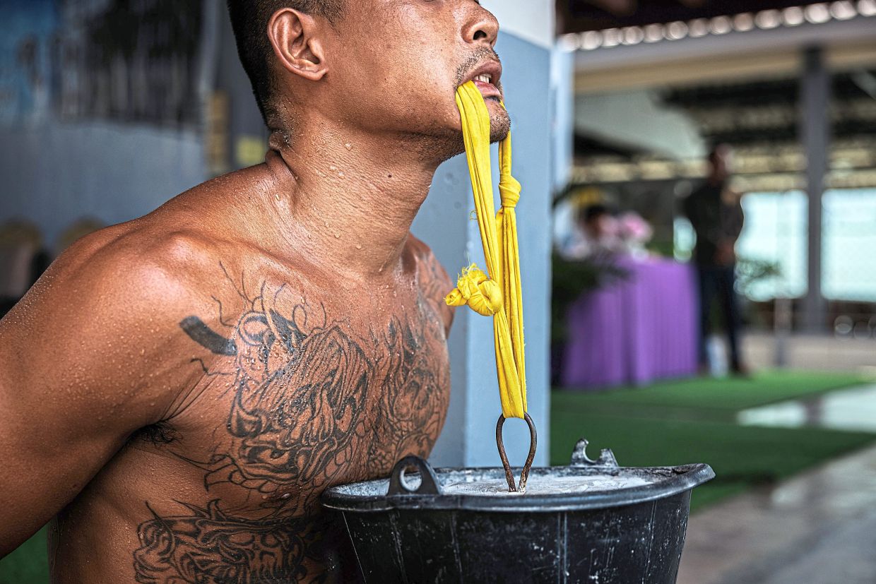 An inmate training to gain strength by lifting a 10kg bucket of cement with his mouth. — ©2024 The New York Times Company