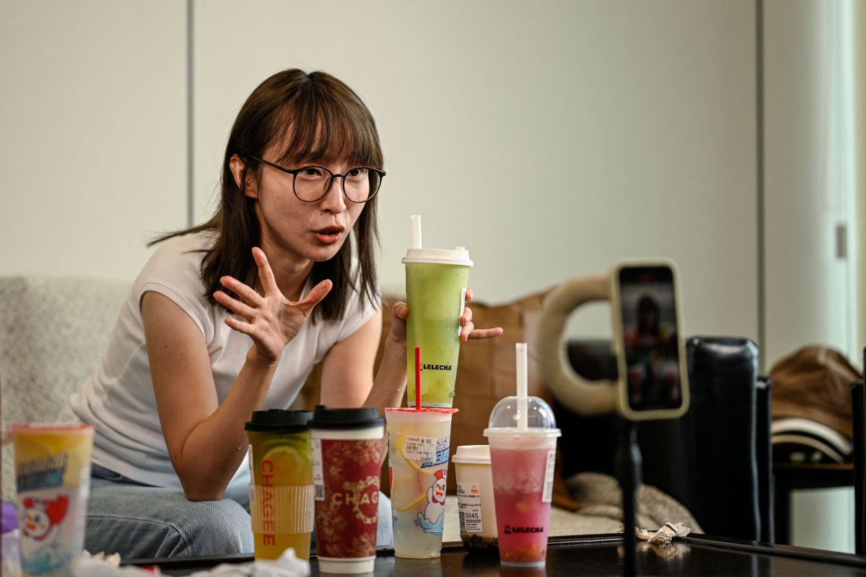 This photo taken on August 15, 2024 shows bubble tea vlogger Stacy Chen recording footage for her vlog at her company in Hangzhou, in eastern China's Zhejiang province.