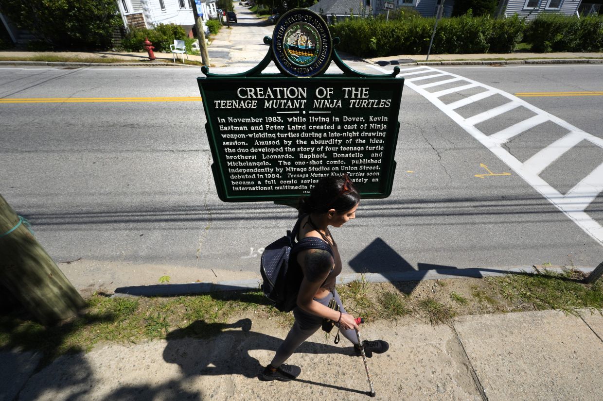 A pedestrian walks past a roadside marker honouring the local creation of the Teenage Mutant Ninja Turtles characters in Dover. Photo: AP 