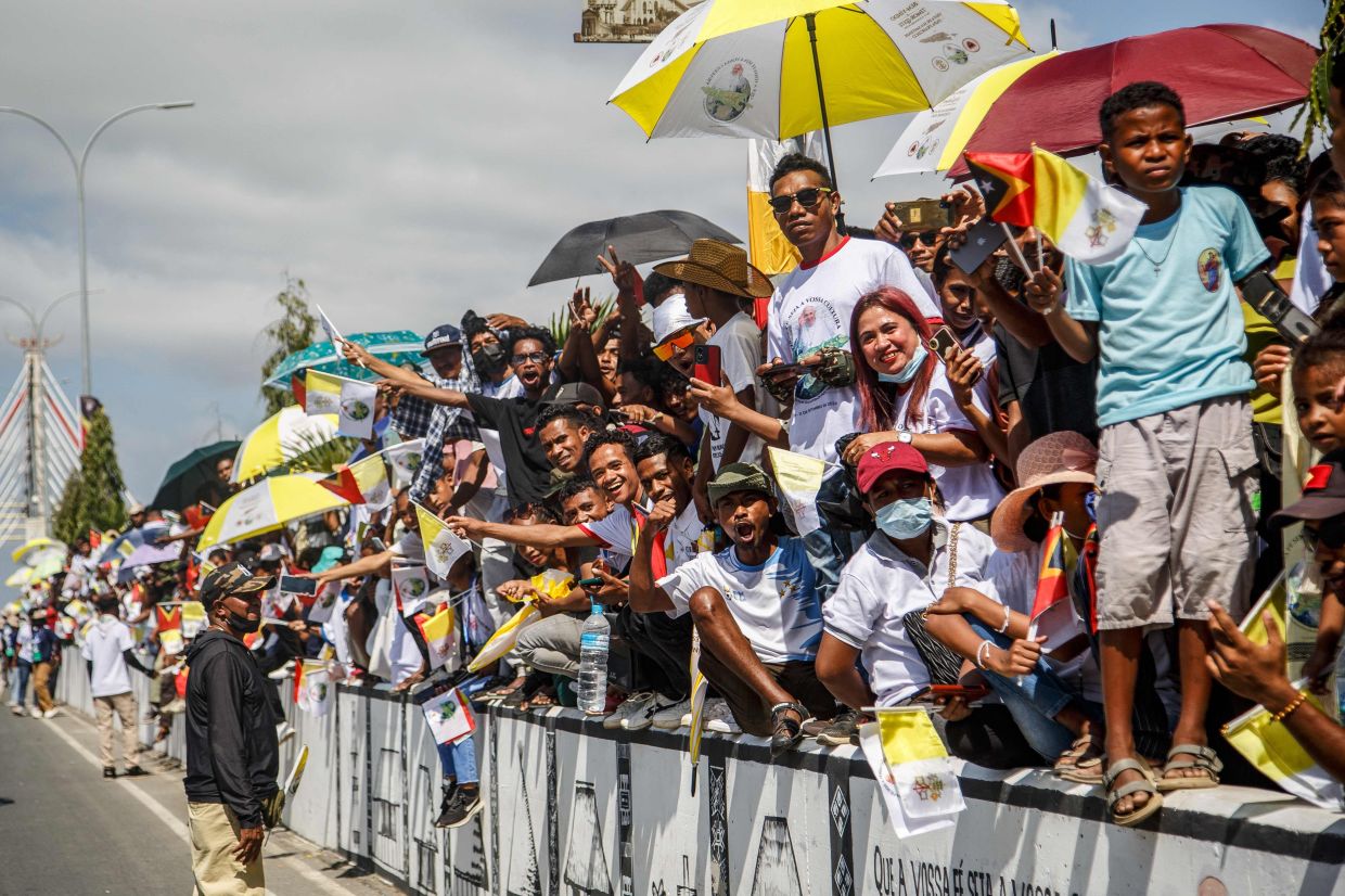 Catholic faithful react as Pope Francis arrives in Dili on Monday, September 9, 2024. Catholic devotees were clamouring to see Pope Francis before his arrival in East Timor's capital on September 9 -- making pilgrimages from faraway towns and hours-long crossings of its shared border with Indonesia. - AFP