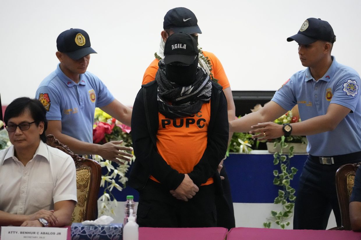 Apollo Quiboloy (centre) a Filipino preacher accused of sexual abuse and human trafficking in the Philippines and similar charges in the United States, is escorted beside Philippine Secretary of Interior and Local Government Benhur Abalos, left, during a press conference at the Camp Crame police headquarters in Quezon City, Philippines Monday, Sept. 9, 2024. - AP