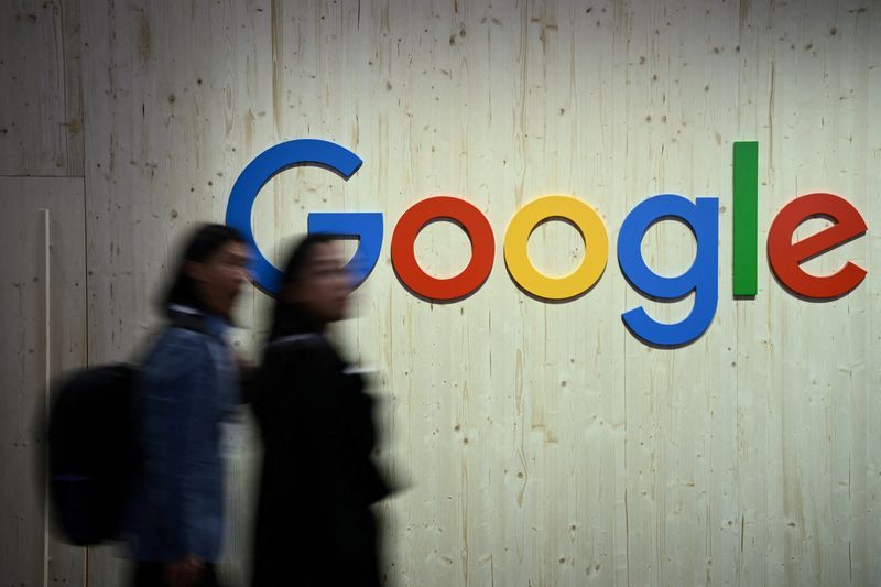FILE PHOTO People walk next to a Google logo during a trade fair in Hannover Messe in Hanover Germany April 22 2024.  REUTERSAnnegret HilseFile Photo