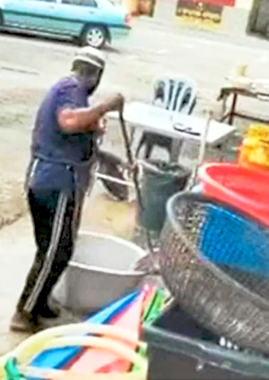 Recipe for disaster: A screen shot of a man, believed to be an employee of a restaurant, cleaning pots using a broom. — Screengrab from social media