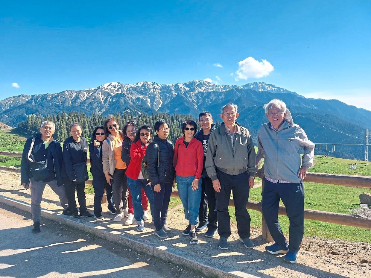 The writer (second from right) with his travel group at a photo spot near Guozigou Bridge between Sayram Lake and Yining.