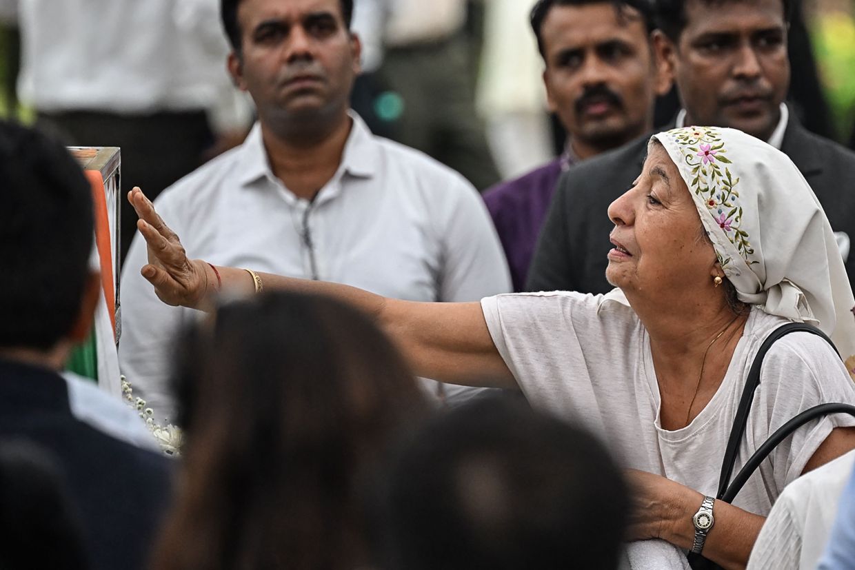 A visitor getting emotional as she pays her respects near the coffin carrying the remains of Indian industrialist. - AFP