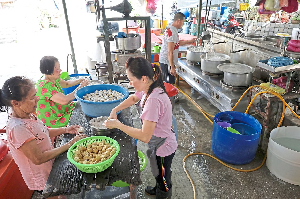 La femme de Phaung et ses deux voisins aident à préparer le yong tau foo sur leur stand à Air Itam.