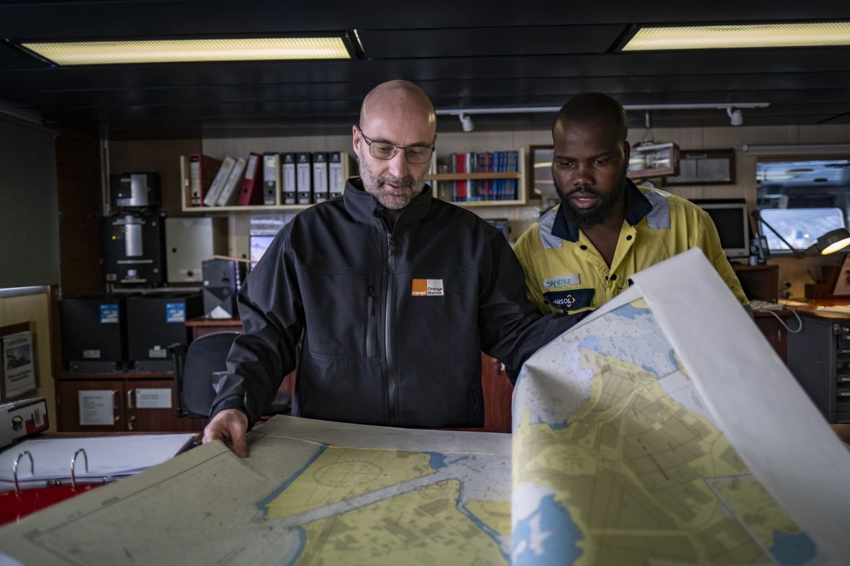 Capt. Benoît Petit, left, with his second officer, Sandile Mthembu, aboard the Léon Thévenin in Cape Town, South Africa, April 30, 2024. Always on call, with sailors rotating in and out to keep the active crew at about 55, the Léon Thévenin is one of six repair ships operated by Orange Marine, a subsidiary of Orange, the French telecommunications giant. — The New York Times