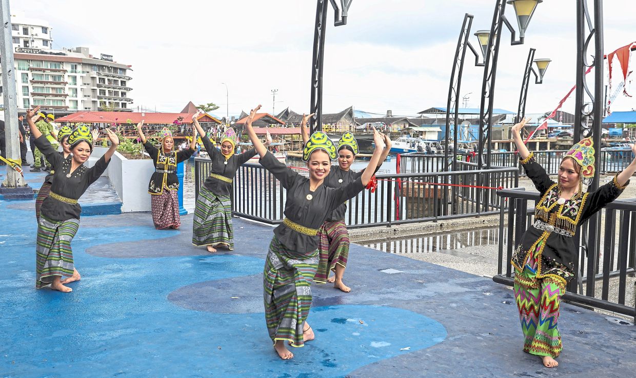 Swimmers racing to catch ducks in the duck-catching competition while traditional dancers perform the lively igal-igal dance.