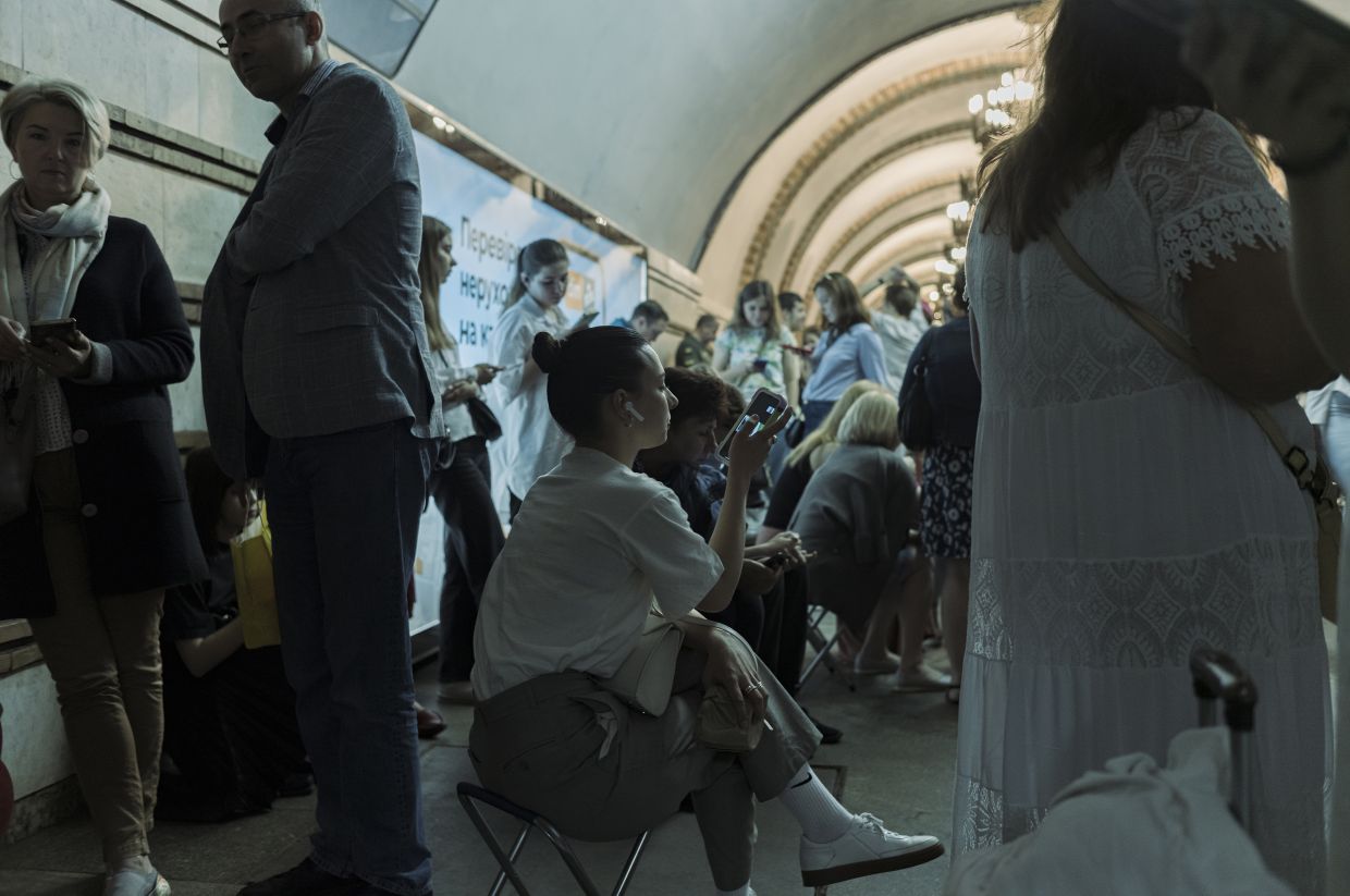 Residents check their phones for real-time updates at an air-raid shelter during a Russian missile strike, in Kyiv, the capital of Ukraine, June 16, 2023. The popularity of the messaging app Telegram has soared during the war with Russia, leading Ukrainian officials to increasingly weigh Telegram’s upsides against its security risks. — The New York Times