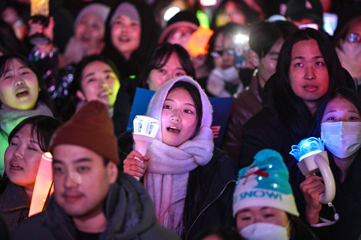 Protesters calling for the ouster of South Korea President Yoon Suk Yeol react after the result of the second martial law impeachment vote outside the National Assembly in Seoul on Saturday, December 14, 2024. South Korean lawmakers on December 14 voted to remove President Yoon Suk Yeol from office for his failed attempt to impose martial law last week.- AFP
