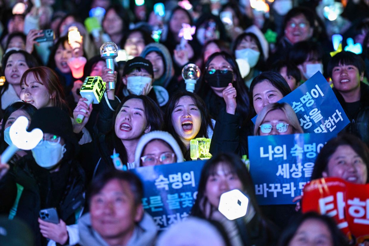 Protesters calling for the ouster of South Korea President Yoon Suk Yeol react after the result of the second martial law impeachment vote outside the National Assembly in Seoul on Saturday, December 14, 2024. South Korean lawmakers on Saturday voted to remove President Yoon Suk Yeol from office for his failed attempt to impose martial law last week. - AFP