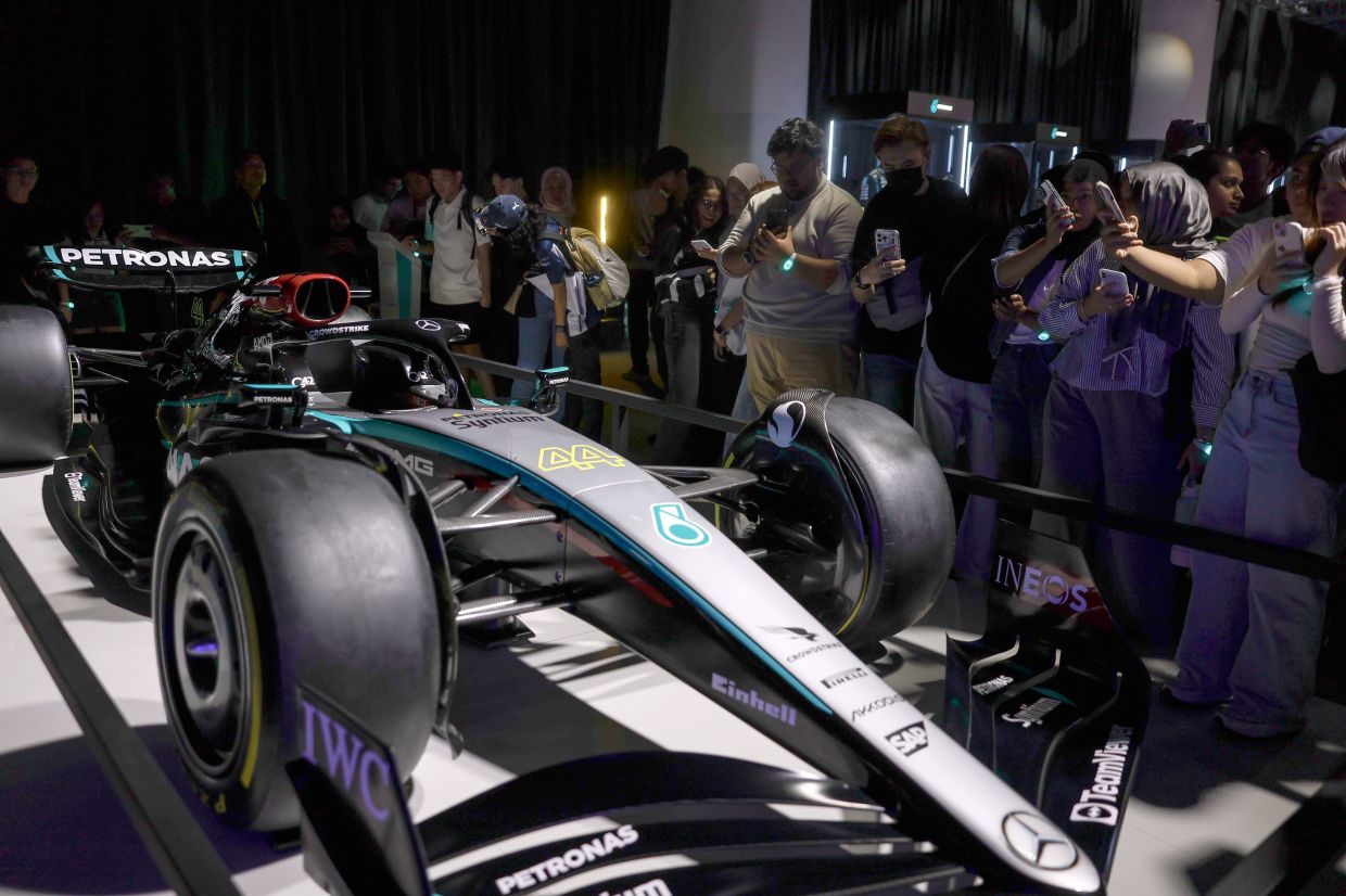 Visitors taking pictures of the iconic car driven by British Formula One legend Lewis Hamilton, showcased at an exhibition during his farewell event for the F1 Mercedes AMG PETRONAS Team at the Kuala Lumpur Convention Centre on Tuesday. — Bernama