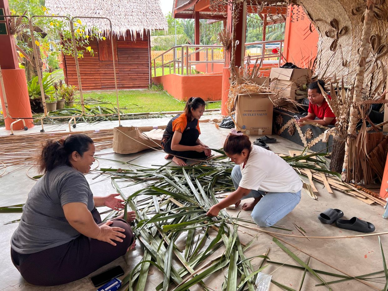 Residents of Kampung Orang Asli Sungai Bumbun hard at work putting together the giant puppets that will star in the 'Awas! Mawas!' parade. Photo:: William Koong