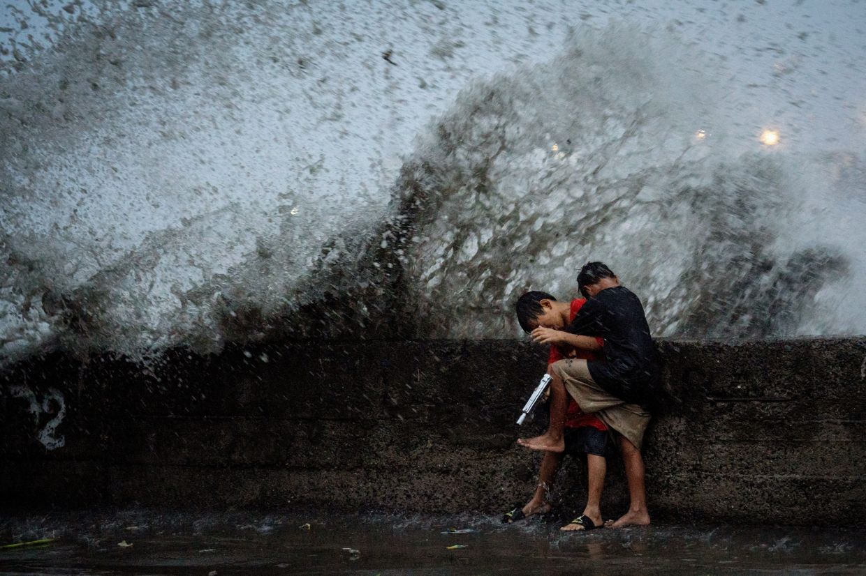Children play near strong waves from the Pasig River amid Super Typhoon Man-yi, in Manila, Philippines, November 17, 2024. - Reuters
