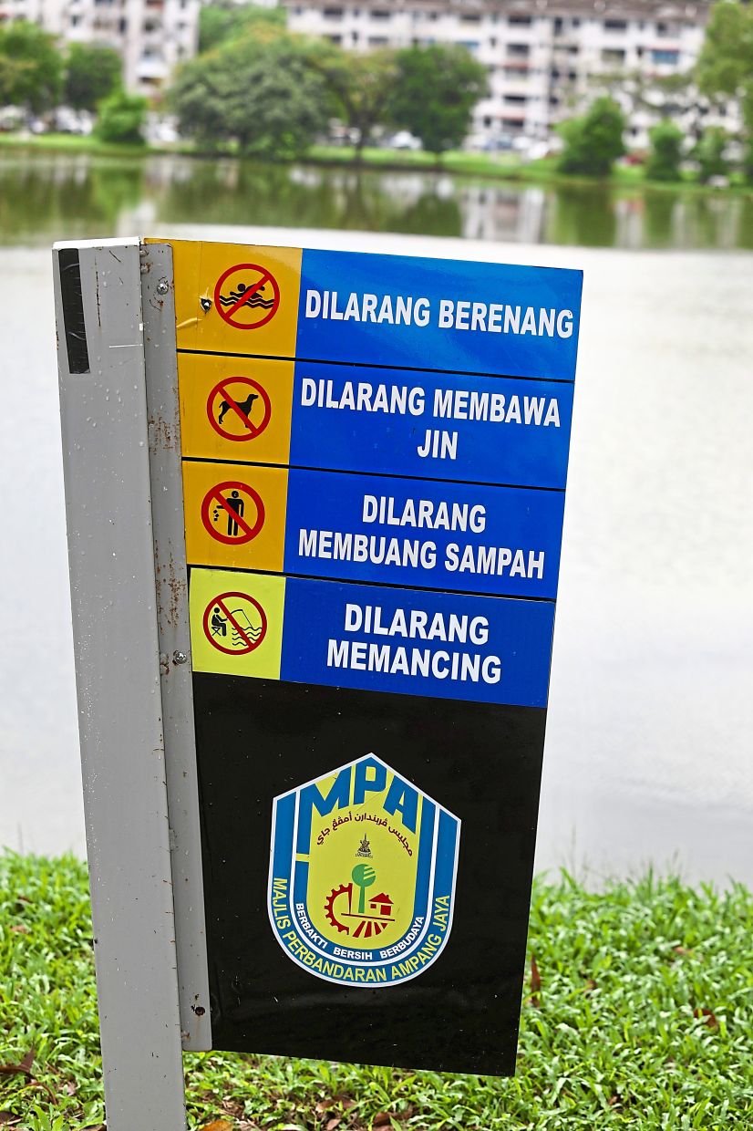 A sign prohibiting fishing activities is seen at the lake. The sign has also been vandalised. — Photos: LOW LAY PHON/The Star