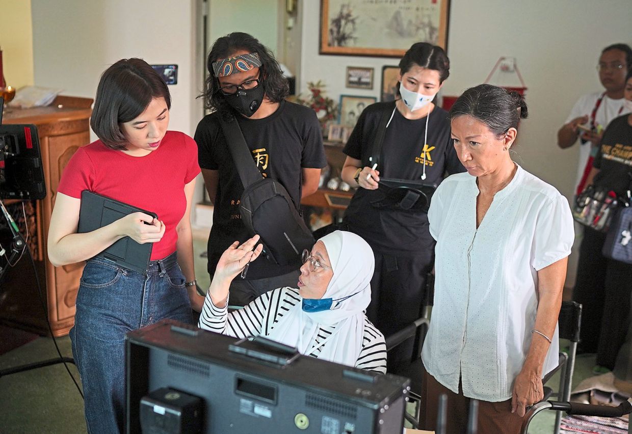 Director Tunku Mona (centre) discuss a scene with Tan (left) and Susan (right) on set of Rain Town. 