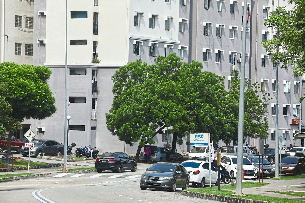 Due to a lack of parking space near the government quarters, residents park by the roadside. — Photos: LOW LAY PHON/The Star