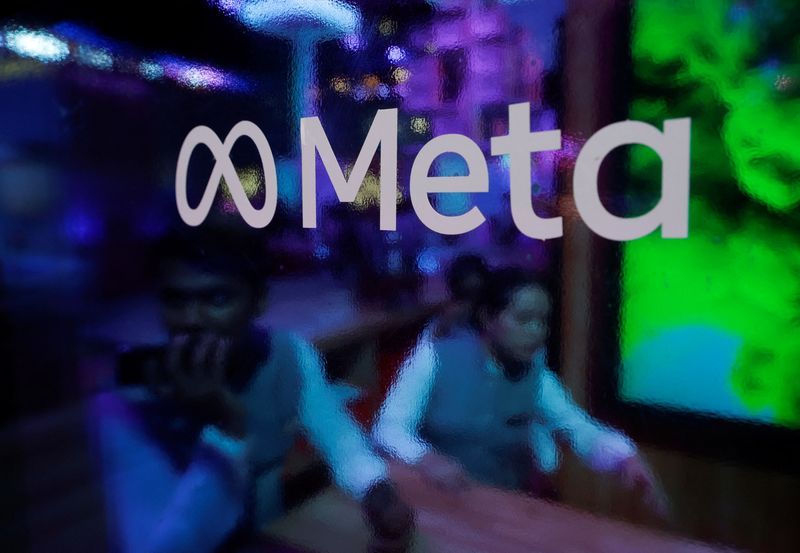 FILE PHOTO People are seen behind a logo of Meta Platforms during a conference in Mumbai India September 20 2023. REUTERSFrancis MascarenhasFile photo